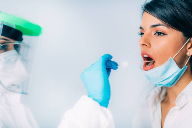 istock Coronavirus test. Medical worker in protective suite taking a swab for corona virus test, potentially infected young woman 1213541559