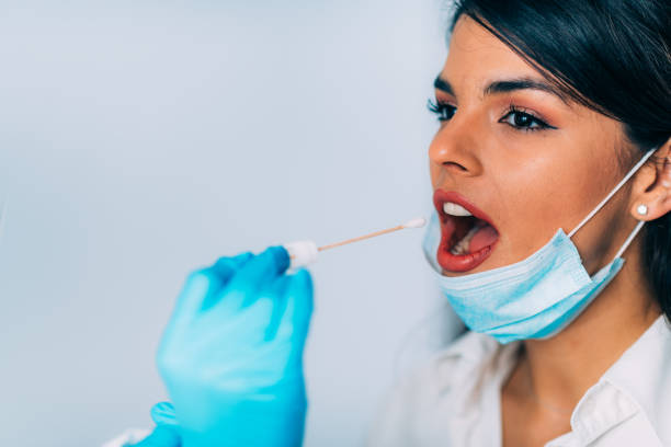 istock Coronavirus test. Medical worker in protective suite taking a swab for corona virus test, potentially infected young woman 1213541586