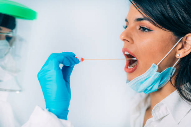 istock Coronavirus test. Medical worker in protective suite taking a swab for corona virus test, potentially infected young woman 1213542311
