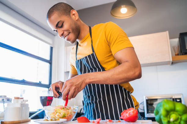 istock Young latin man preparing food at home. 1213544184