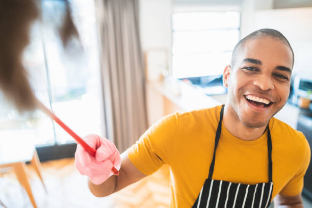 istock Young latin man dusting his new house. 1213544215
