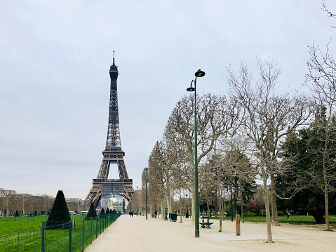 Champ-de-Mars is empty in Paris, during pandemic 2020 in Europe. There are no much people. Schools, bars, shops, restaurants, theatre... are closed. Every body is confine at home. Paris in France, March 16, 2020.