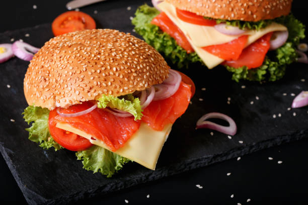 istock Hearty appetizing fish hamburgers in plates on the table 1213550512