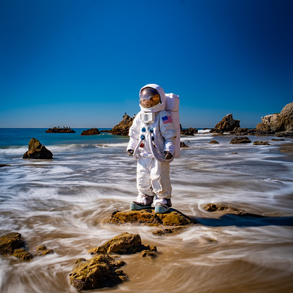 An astronaut stands in the shallow waves of Malibu's El Matador Beach. It's weird, unique, doesn't make any sense... and yet for some reason, it's really cool.