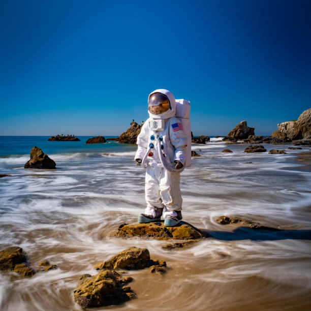 Spaceman in the Surf An astronaut stands in the shallow waves of Malibu's El Matador Beach. It's weird, unique, doesn't make any sense... and yet for some reason, it's really cool. cosplay photos stock pictures, royalty-free photos & images