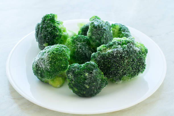 istock frozen green broccoli on the white plate and white background 1213551171