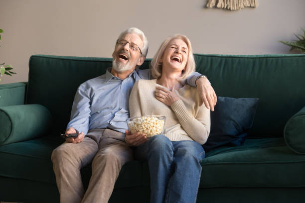 istock Excited mature couple laughing while watching comedy movie. 1213552184
