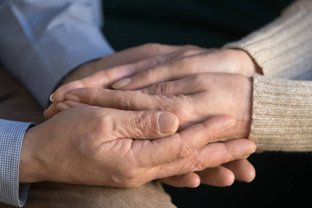 istock Close up middle aged man holding wrinkled wife hands. 1213552196
