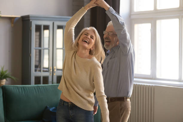pareja mayor encantada relajarse bailando en casa - men middle senior adult human age fotografías e imágenes de stock