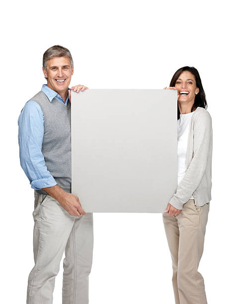 istock Happy mature man and woman holding an empty billboard 121355221