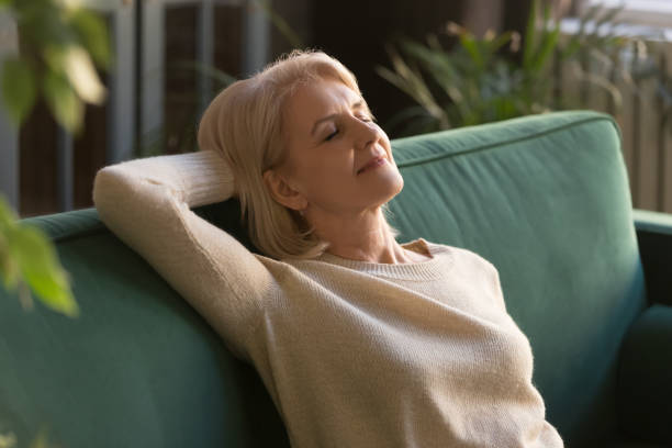 istock Exhausted mature woman relax on couch with eyes closed 1213552225