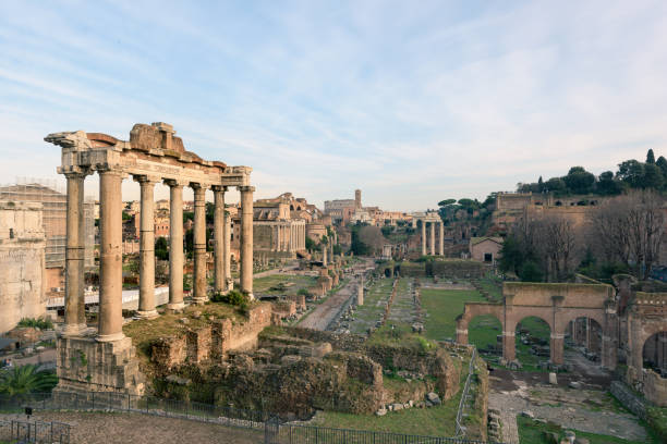 Ruins of the Roman Forum at dusk in Rome, Italy Cityscape of the Roman Forum ruins with the Arch of Severus, temple of Saturn, temple of Vesta, Basilica of Maxentius, Arch of Titus and Colosseum in Rome, Italy ancient rome stock pictures, royalty-free photos & images