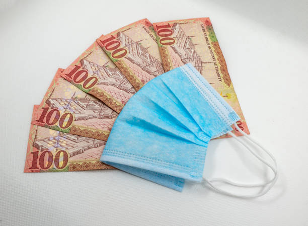 istock Saudi Arabian 100 Riyal bank note with surgical protective face mask 1213555382