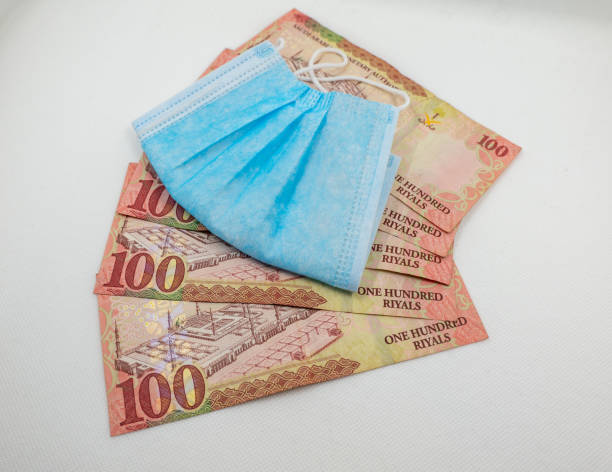 istock Saudi Arabian 100 Riyal bank note with surgical protective face mask 1213555767