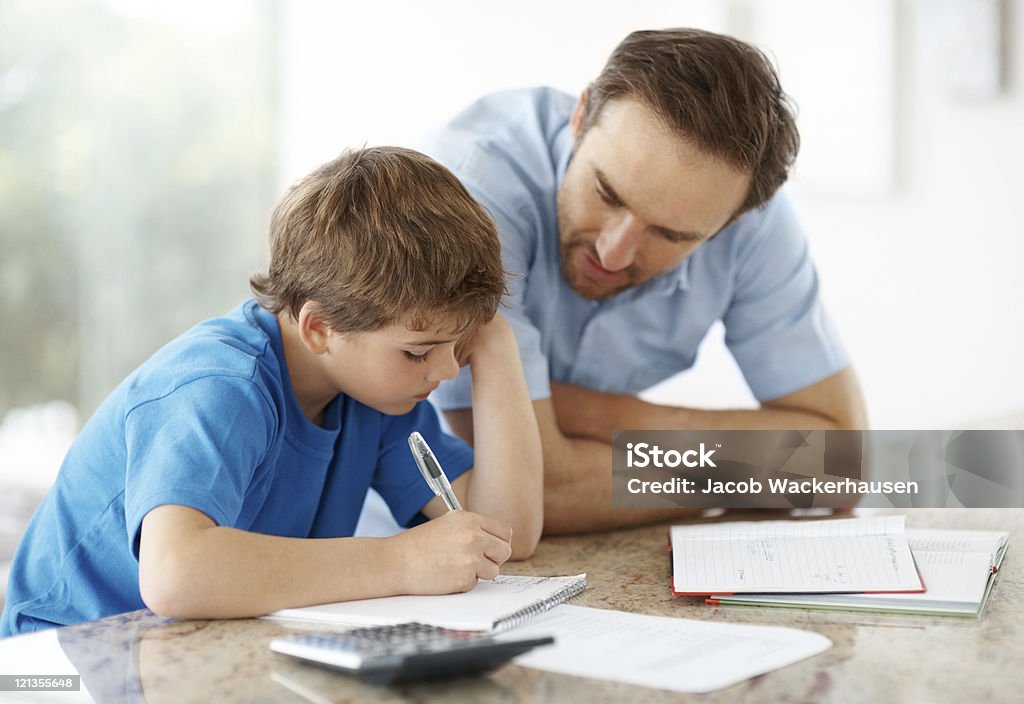 Junger Mann Unterstützung von seinem kleinen Sohn mit Arbeit und Familie in Verbindung. - Lizenzfrei Akademisches Lernen Stock-Foto