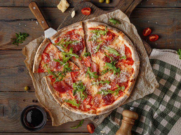istock tasty gourmet meat pizza on a rustic wooden table with a sliced slice in the kitchen setting, top view 1213556936