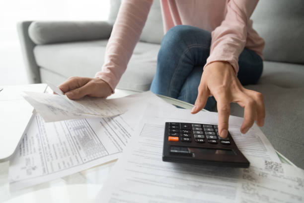 istock Woman holding bills using calculator manage finances, close up view 1213557421
