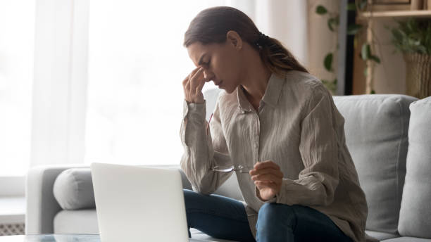 müde junge frau mit brille fühlen augenzug nach computerarbeit - human eye rubbing tired glasses stock-fotos und bilder