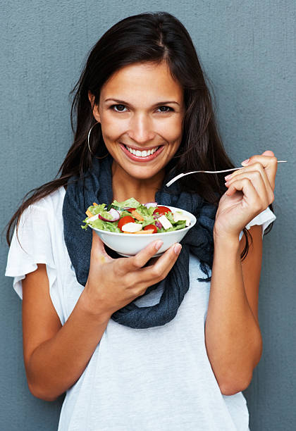 istock Woman smiling while holding bowl of salad 121355896