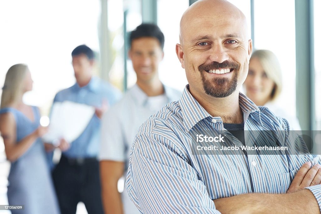 Hombre de negocios de pie con sus elite equipo de negocios en el fondo - Foto de stock de 30-39 años libre de derechos