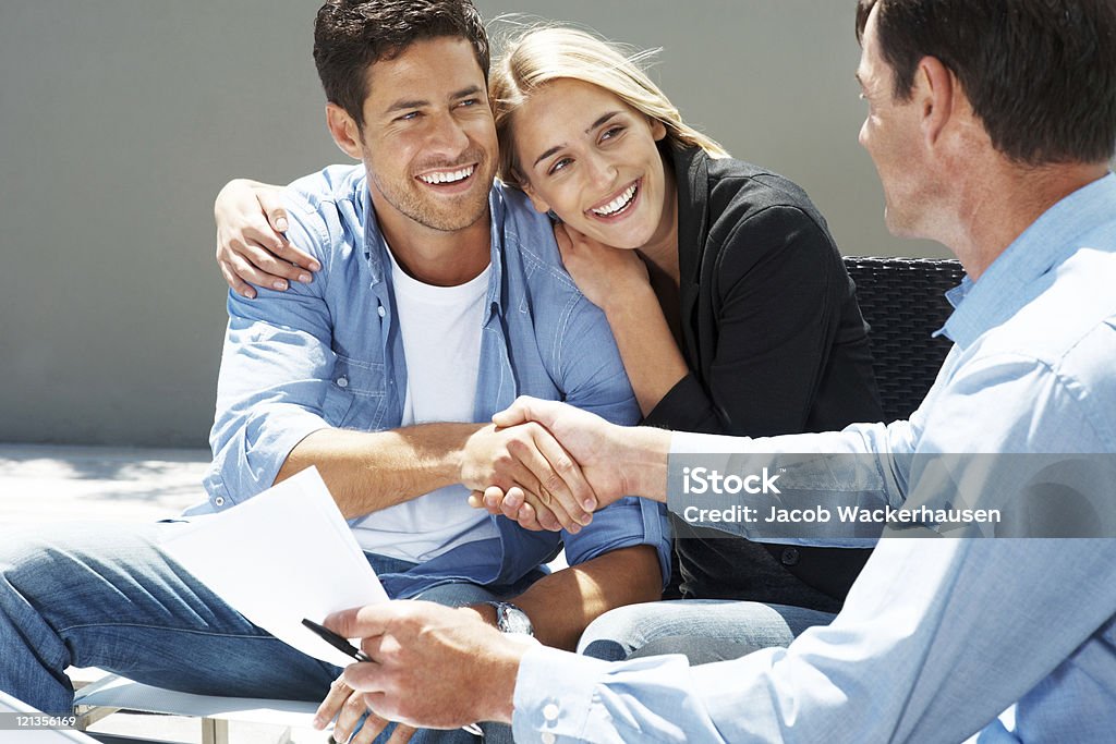 Feliz Jovem casal aperto de mão com consultor - Foto de stock de 20 Anos royalty-free