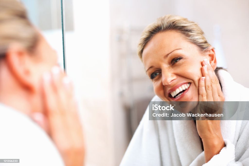 Feliz Mulher Madura admirar-se ao espelho - Royalty-free Tratamento de pele Foto de stock