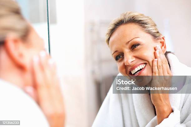 Feliz Mulher Madura Admirarse Ao Espelho - Fotografias de stock e mais imagens de Tratamento de pele - Tratamento de pele, Mulheres Maduras, Mulheres