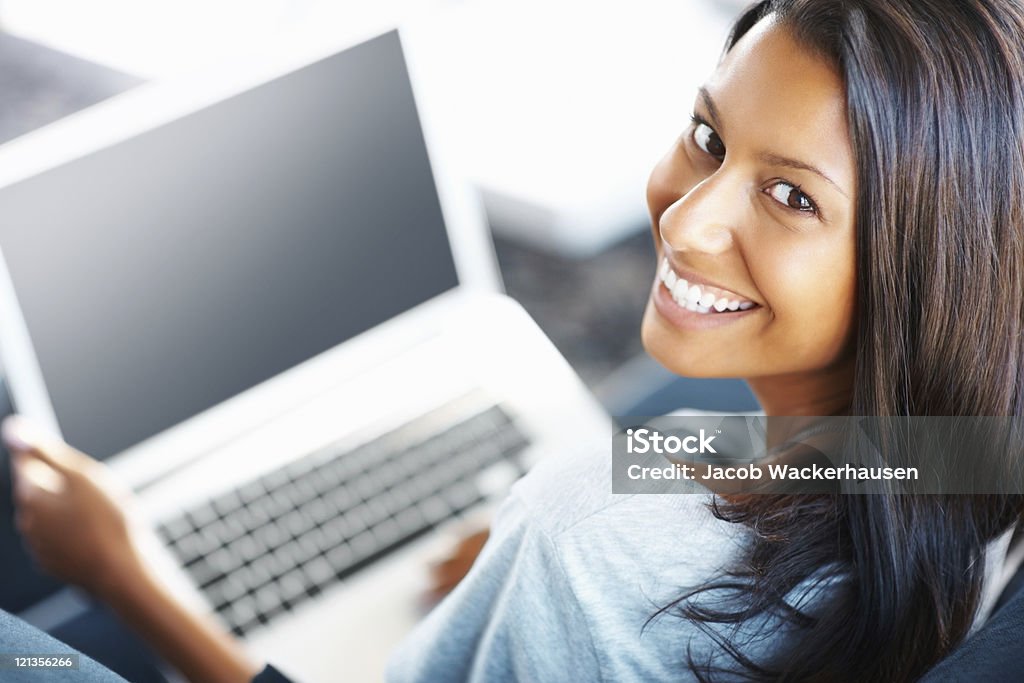 Attraente donna che lavora sul suo computer portatile - Foto stock royalty-free di Lavoro a domicilio