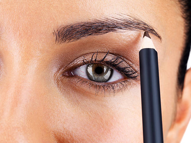 atractiva mujer aplicar lápiz de cejas - makeup pencils fotografías e imágenes de stock