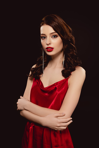 beautiful young woman in red dress. studio shot. white background. fashion shoot.