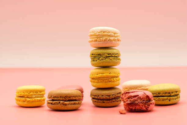 istock delicious macarons full and bitten and crumbs arranged on colored background 1213567366
