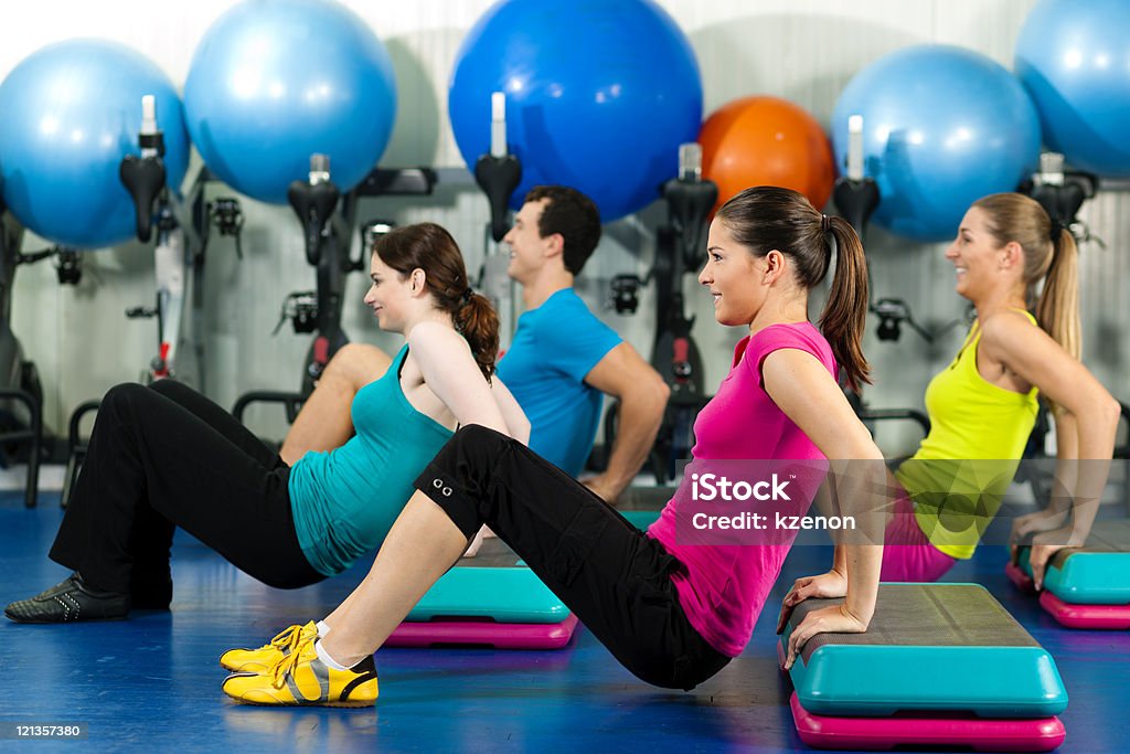 People in gym on step board Fitness People in gym on step board; strengthening the abdominal muscles Activity Stock Photo