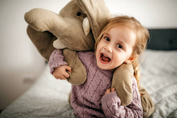 Cute girl playing with toy in bedroom