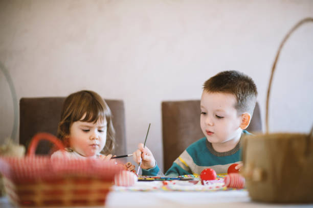 istock Children painting Easter eggs at home 1213574668