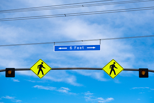 Conceptual digital composite - Road signs telling people to practice social distancing and to stay 6 feet apart. These signs are in response to the covid-19 pandemic.