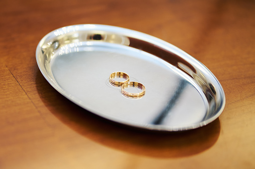 two beautiful gold wedding rings on a tray on the table