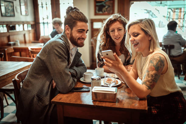 istock Best friends using smart phone in local coffee shop 1213580147