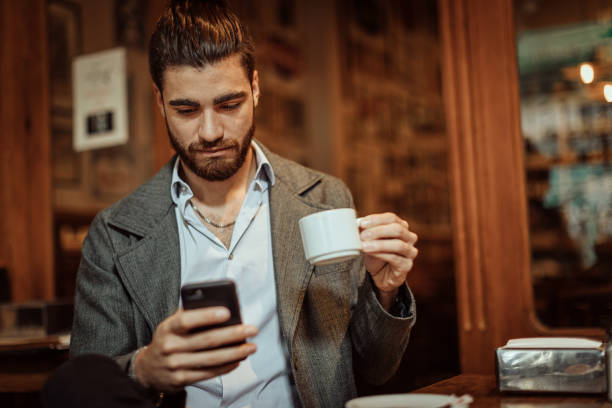 istock Hipster man having coffee and surfing the net at cafe 1213580170
