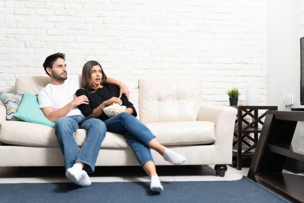 istock Heterosexual Couple Watching TV At Home 1213581407