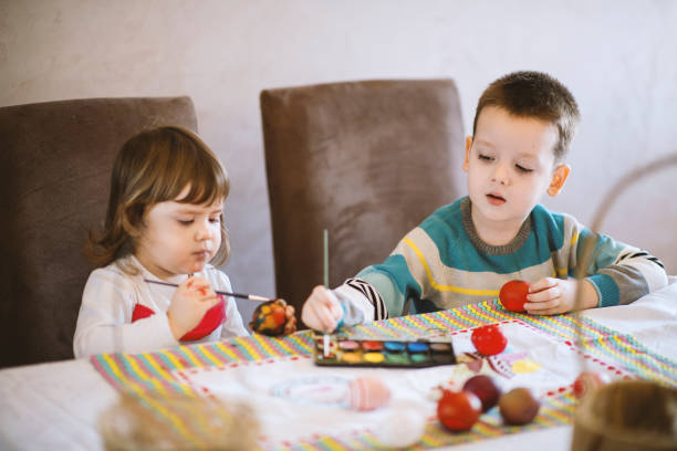 istock Children painting Easter eggs at home 1213582412