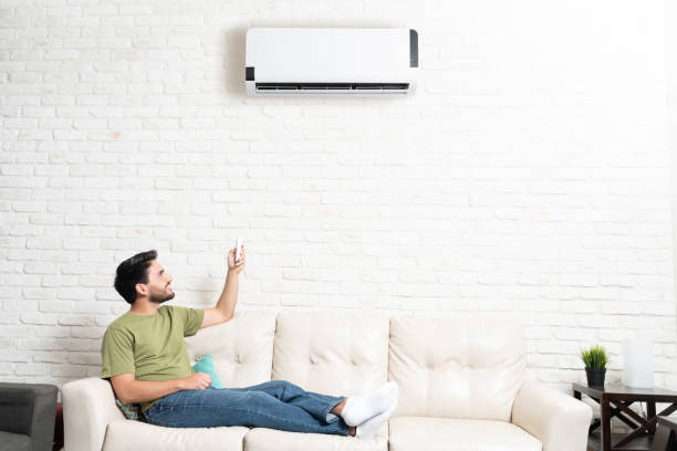 istock Man Turning On Air Conditioner At Home 1213583712