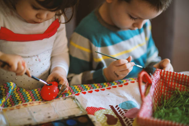 istock Children painting Easter eggs at home 1213583735
