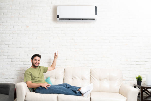 istock Man Is Adjusting Temperature Of Air Conditioner In Room 1213583737
