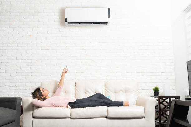 istock Woman Turning On Mini Split At Home 1213583772