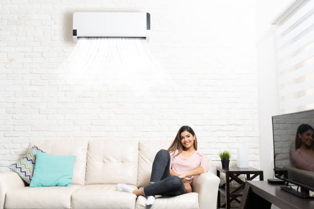 istock Pretty Woman Resting On Sofa Below Air Conditioner 1213583821