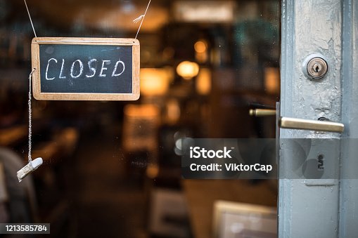 istock Closed - sign hanging on glass door 1213585784