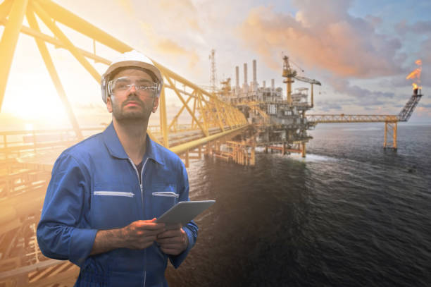 Caucasian man engineer staff worker with tablet in hand and offshore rig background concept.