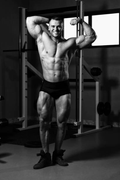 istock Biceps Pose Of A Young Man In Gym 1213589556