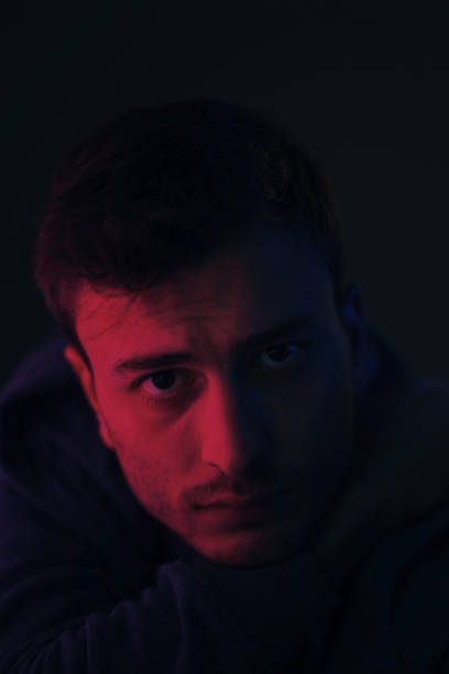 istock Young male looking at camera in an artificially illuminated environment 1213591149
