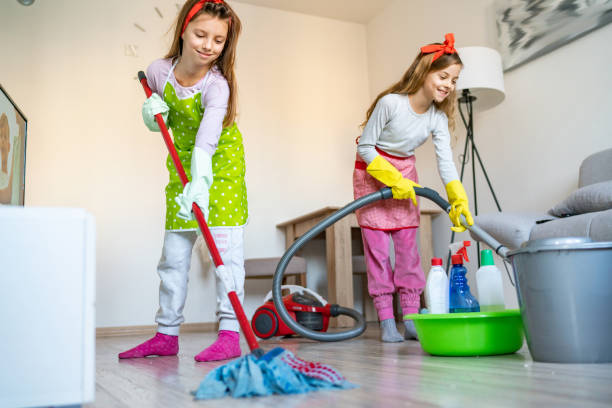 istock LIttle sisters clean the house 1213591903